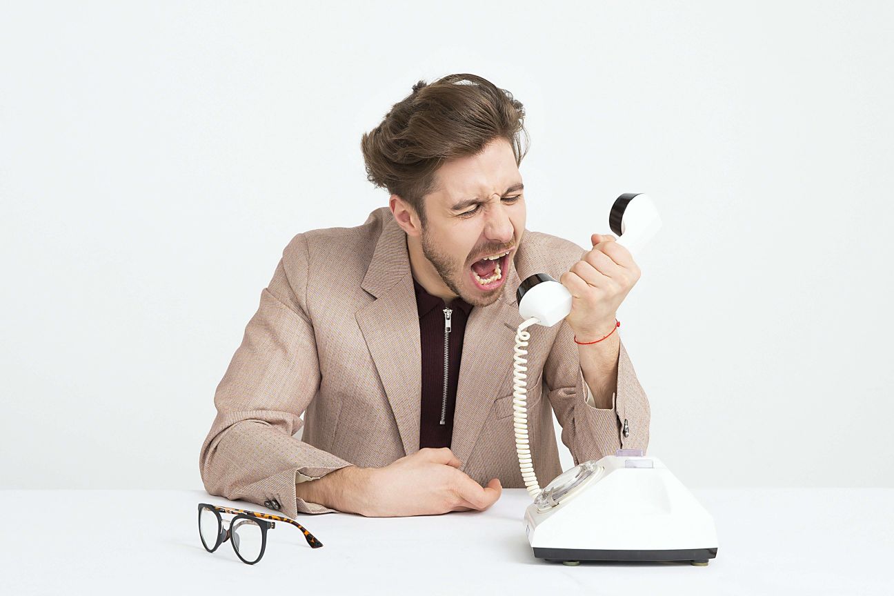 Image of a frustrated man on the phone.